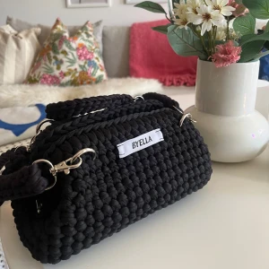 Svart handväska  - En svart ”clutch” med avtagbara axelband, går också att använda som necessär. Virkad av mig 🧶