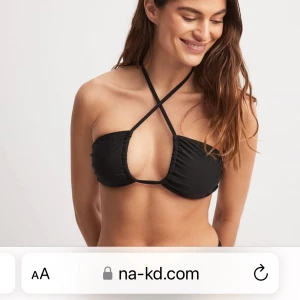 Svart bikiniöverdel från NA-KD - Trendig svart bikiniöverdel från NA-KD med smala axelband som korsas framtill. Bikinin har en stilren design med lätt rynkade kupor och knyt i ryggen. Perfekt för dig som vill ha en modern och enkel look på stranden.