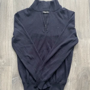 merinoull quarter zip från J.Lindeberg - Säljer en svart långärmad tröja från J.Lindeberg i 100% merinoull. Tröjan har halv dragkedja vid halsen och diskret broderad logga på bröstet. Perfekt för en stilren och bekväm look.