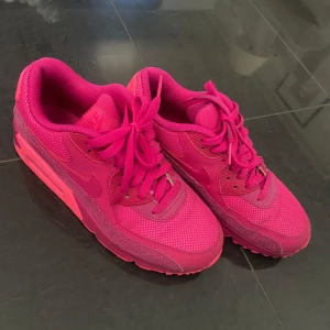Nike Air Max i helrosa - Säljer ett par Nike Air Max sneakers i en riktigt snygg helrosa färg. Skorna har klassisk Air Max-sula, mesh- och syntetdetaljer samt rund tå. Perfekta för dig som vill sticka ut med färg på fötterna!