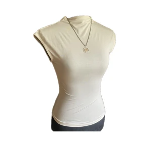 Figurnära polo topp - Super fin figurnära topp med hög hals och korta ärmar. Passar till vardag, fester eller vara finklädd! Helt oanvänd! 💛Storlek XS (passar XXS). Skick 10/10!  