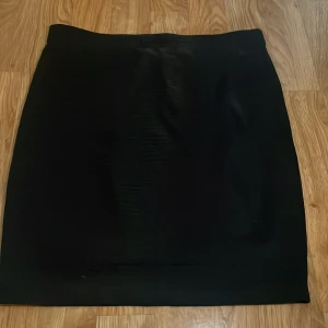 Svart tight kjol från SALLY & CIRCLE - Enkel och stilren svart tight kjol från SALLY & CIRCLE i storlek S. Kjolen har en klassisk rak passform och är perfekt att matcha med olika toppar. Materialet känns mjukt och den är jättebekväm.  Den är använd få gånger, säljer pågrund av att den inte kommer till användning. Pris kan diskuteras.