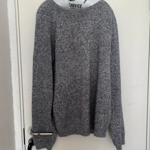 Gråmelerad stickad tröja från These Glory Days - Säljer en gråmelerad stickad tröja från These Glory Days i storlek Large. Tröjan har lång ärm och rund halsringning, perfekt för kyligare dagar. Enkel och stilren design som passar till det mesta.