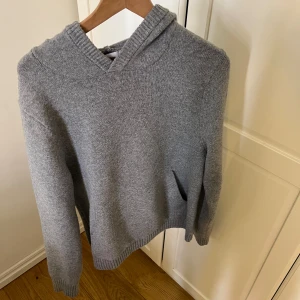 Grå stickad hoodie  - Mysig grå stickad hoodie från Goodfellow & Co. Tröjan har lång ärm, huva och ribbade muddar vid ärmslut och nederkant. Perfekt för kyliga dagar och enkel att matcha med jeans eller andra byxor. Storlek s men passar  m. Knappast använd. Skriv om du har frågor🤗