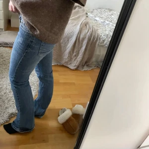 Blå bootcut jeans - Säljer ett par klassiska blå bootcut jeans med normal passform. Jeansen har fem fickor och stängs med dragkedja och knapp. Perfekta till vardags och lätta att matcha med olika toppar. Dem har slitningar vid höften och längst foten💕