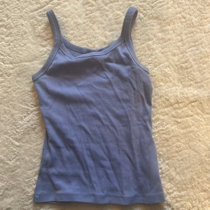 Ljuslila ribbad linnetopp - Säljer en ljuslila ribbad linnetopp med breda axelband. Perfekt för varma dagar och enkel att matcha med jeans eller kjol.