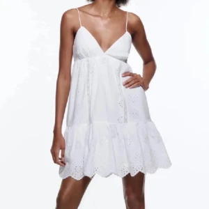 Zara klänning vit - Säljer min trendiga sommarklänning från Zara. Söt vit klänning med smala axelband och v-ringning. Klänningen har broderade blommor och volang nertill, samt en luftig passform som passar perfekt till varma dagar. Man knyter axelbanden baktill och kan därav justera storleken hur man vill att den ska sitta. 