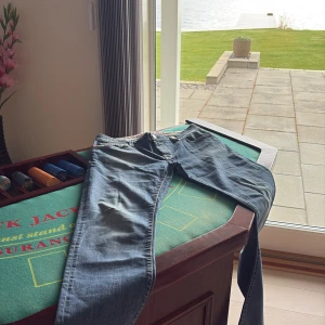 Blå jeansbyxor från tramarossa - Klassiska blå  jeans med raka ben och normal passform från tramarossa. Byxorna har fyra fickor, knappgylf och snygga röda detaljer vid bakfickorna. Perfekta för en avslappnad stil och funkar året runt. Size 34