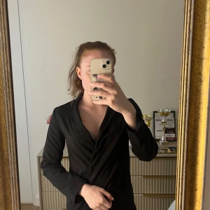 Svart skjorta med v-ringning - Säljer en svart skjorta med v-ringning och långa ärmar. 