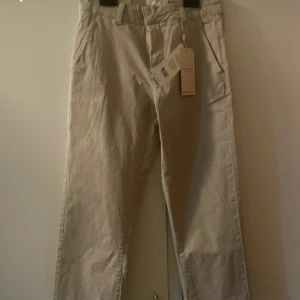 Beige byxor från Part Two - Snygga beige byxor från Part Two i modellen SofiynsPW. Klassisk rak passform med fickor i sidorna och hällor för bälte. Perfekta för en stilren och enkel look. Färgen heter White Pepper.