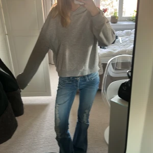 Grå hoodie - Säljer en bekväm grå hoodie med normal passform. Tröjan har långa ärmar och en klassisk huva. Perfekt för en avslappnad stil.