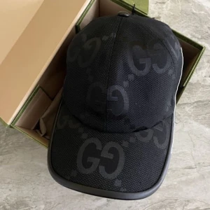 Svart Gucci keps  - Snygg svart keps med ett diskret GG-mönster. Perfekt för att ge din outfit en stilren touch. Kepsen har en klassisk design med böjd skärm.