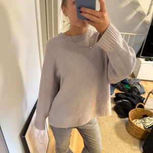 Ljuslila stickad tröja från COS - Säljer en mysig ljuslila stickad tröja från COS. Tröjan har en rund halsringning och långa ärmar med ribbade muddar. Perfekt för kyliga dagar. Hör av dig vid intresse! 💜100% ull