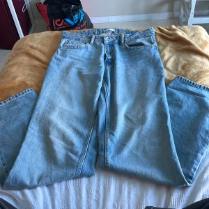 Blå jeans från Gina Tricot - Säljer ett par snygga blå jeans från Gina Tricot. De har en low waist och straight fit, perfekt för en avslappnad stil. Jeansen är i en klassisk blå färg och passar till många olika outfits.