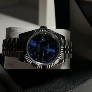 Lyxig klocka med blå urtavla - Snygg klocka med en djupblå urtavla och silverfärgad boett. Armbandet är i rostfritt stål med en klassisk länkdesign. Perfekt för den som vill ha en elegant och tidlös accessoar.