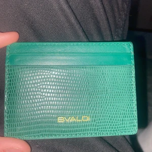 Grön plånbok från Bvaldi - Snygg grön plånbok från Bvaldi med en stilren design. Perfekt för att hålla dina kort och kontanter organiserade. Den har en texturerad yta som ger en lyxig känsla. Passar perfekt i fickan eller väskan.