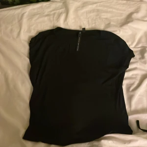 Svart topp från The Black Label Collection lager 157 - Snygg svart topp från The Black Label Collection lager 157. Perfekt för en stilren look. Toppen har en enkel design och är tillverkad i ett mjukt material.