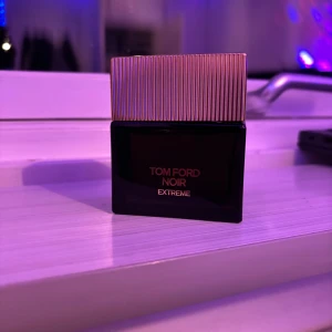 Tom Ford Noir Extreme Eau de Parfum - Säljer en elegant Tom Ford Noir Extreme Eau de Parfum i en stilren svart flaska med guldlock. Flaskan rymmer 50 ml och är helt full och har en lyxig känsla med en modern design. Perfekt för den som vill ha en sofistikerad doftupplevelse. Säljer den då jag fick den som present av en kompis men jag har redan en likadan.