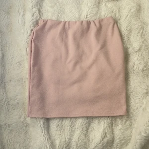 Rosa kjol från Boohoo - Säljer en söt rosa kjol från Boohoo. Kjolen har en enkel design med en mjuk och bekväm passform. Perfekt för att matcha med olika toppar och accessoarer. Passar bra för både vardag och speciella tillfällen.