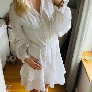 Vit klänning med volanger - Säljer en söt vit klänning med volanger och knappar framtill. Ny med prislapp, original pris 599kr!! Super fin till sommar o student!