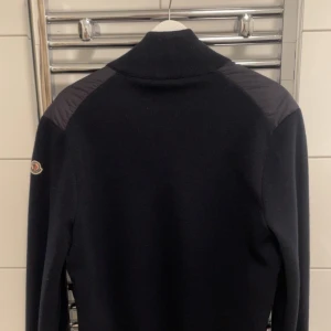 Navy blå moncler cardigan - Säljer en stilren navyblå cardigan från Moncler. köpt på facebook gruppen highend sweden. Den är äkta och har använts sparsamt jacka har inga flaws och ser fortfarande ny ut