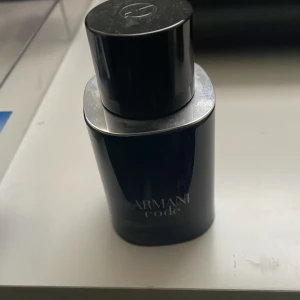 Armani Code herrparfym - Säljer en elegant herrparfym från Armani Code. Flaskan är stilrent designad i svart med en rund form och ett matchande svart lock. Perfekt för den som söker en sofistikerad doft. Ungefär 45 ml kvar