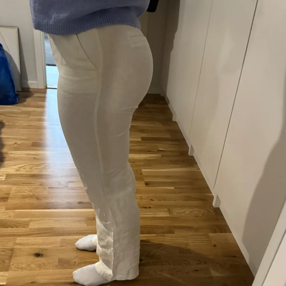 Snygga beiga linnebyxor med en rak passform. De är högmidjade och tillverkade i ett bekvämt material som ger en stilren look. Perfekta för en avslappnad men ändå chic stil.. Farkut & Housut.
