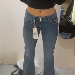 Blå bootcut jeans - Snygga blå bootcut jeans med låg midja. Perfekta för en avslappnad stil. 