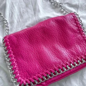 Rosa TIAMO väska 🩷🩶 - En jättefin rosa TIAMO axelremsväska använd vid ett tillfälle så i nyskick! Nypris 499kr! FÖRST TILL KVARN!🩶🩷(BUNDLERABATT VID KÖP AV FLER ARTIKLAR!)