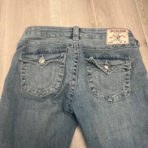 True Religion Joey jeans - Snygga blå lågmidja bootcut jeans från True Religion. Storlek 26!