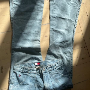 Blå low waist jeans från Tommy Hilfiger - Snygga blå jeans från Tommy Hilfiger med klassisk design. De har en normal passform och är tillverkade i jeansmaterial. Perfekta för en avslappnad stil.