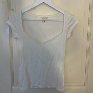 Vit v-ringad topp  - Säljer en enkel och stilren vit topp från Nelly. Aldrig använd 