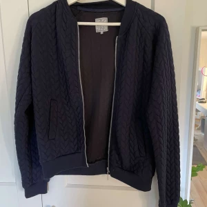 Marinblå quiltad bomberjacka från Zink - Säljer en marinblå quiltad bomberjacka från Zink i storlek XS (Mer likt S). Tröjan har dragkedja framtill, ribbade muddar och ett snyggt mönster i tyget. Perfekt för dig som vill ha en stilren och bekväm tröja med lite extra struktur💗Använd inte köp nu!