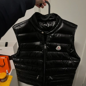 Moncler väst - Den är använd men fortfarande mycket bra skick, inga märken på den. Storlek 2 som motsvarar M, kan även passa S