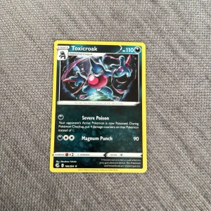 Pokémonkort Toxicroak - Säljer ett Pokémonkort med Toxicroak, HP 110. Kortet har gul ram och motivet visar Toxicroak i en dynamisk pose. Kortet har attacker som Severe Poison och Magnum Punch. Perfekt för samlare eller Pokémonspelare.