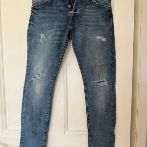 Blåa jeans från Jack and Jones  - Säljer ett par blå jeans med slitningar från Jack and Jones. Modell: Slim/Glenn. Strolek 32/34. Bra skick. Bara o höra av er vid frågor 