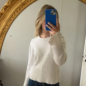 Vit ribbad stickad tröja - Säljer en vit stickad tröja med ribbade detaljer vid ärmslut och nederkant. Använt ett fåtal gånger 