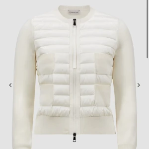 Vit quiltad cardigan jacka från Moncler - Säljer en stilren vit cardigan jacka från Moncler med quiltad framsida och två stickade fickor. Jackan har långärmade stickade ärmar och dragkedja framtill. Perfekt för lager-på-lager och snygg till många outfits. Köpt för runt 9000kr