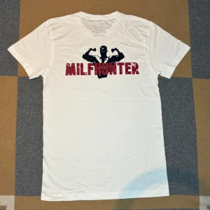 Milfhunter t-shirt ifrån Revenite  - Vit t-shirt från Revenite.                                                                     Storlek: S                                                                                 Helt ny ✅.                                                                                      Rabbat om man följer 🙌✅