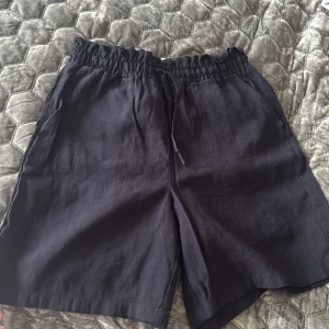 Svarta shorts från LC Waikiki Classic - Svarta shorts från LC Waikiki Classic med resår och snörning i midjan. Tillverkade i ett mjukt tyg med sidofickor och avslappnad passform. Perfekta för varma dagar och enkel att matcha med olika toppar.