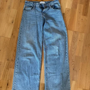Blå wide leg jeans från Motel Denim - Säljer ett par blå jeans från Motel Denim med breda ben och klassisk femficksdesign. Jeansen har hög midja och stängs med knapp och dragkedja. Perfekta för dig som gillar en avslappnad och trendig look.