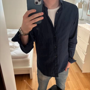  Oscar Jacobson linneskjorta - Nyskick! - Säljer min mörkblåa linneskjorta från Oscar Jacobson. Skjortan är ALDRIG ANVÄND! Därmed helt i nyskick. Nypriset är 1400kr och jag säljer min för 799kr, men kan vara öppen för prissänkning vid smidig affär. Hör av er vid frågor!