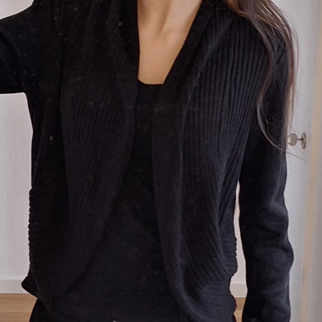 Svart kofta med ribbade detaljer