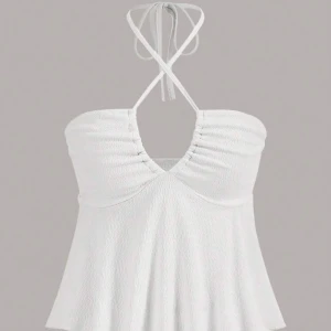 Vit halterneck linnetopp - Säljer en fräsch vit halterneck topp med knyt i nacken och lätt rynk vid bysten. Toppen har en croppad passform och är tillverkad i ett lätt, strukturerat material. Perfekt för varma dagar!