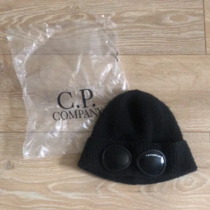 Svart C.P. Company mössa - Hej! Säljer mössan eftersom att jag vill byta stil. Mössan är köpt i Plick vilket gör mig osäker ifall den är äkta. Jag har använt den ett par gånger och mössan var köpt för ungefär två månader sen. Den har inga skador, repor eller något liknande. Kan mötas i stockholm. Pris kan diskuteras vid snabb affär! 