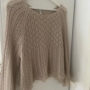 Beige stickad spetsmönstrad tröja från ONLY - Säljer en beige stickad tröja från ONLY med vackert spetsmönster. Tröjan har lång ärm och är tillverkad i ett luftigt, mjukt material som ger en bohemisk känsla. Perfekt att styla över ett linne eller klänning.