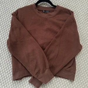 Brun croppad sweatshirt från Zara - Mörkbrun croppad sweatshirt från Zara med rund halsringning och långa ärmar. Normal i storleken 