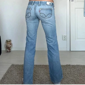 Ljusblå Levis jeans - Säljer ett par ljusblå Levis 501 jeans med raka ben och låg midja. Snedknapp och ett litet hål vid knät. Första bilden är tagen av gamla ägaren. Knappt använda, säljer för att de inte kommer till användning. 