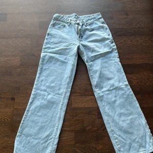 Ljusblåa jeansbyxor med raka ben - Säljer ett par ljusblåa jeansbyxor med raka ben och klassisk femficksdesign. Byxorna har normal passform och stängs med dragkedja och knapp framtill. Perfekta för en avslappnad stil.