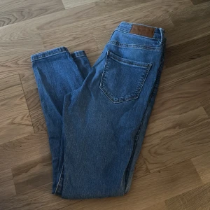 Blå jeansbyxor från Vero Moda - Säljer ett par klassiska blå jeansbyxor från Vero Moda. Byxorna har fem fickor, normal passform och raka ben. Perfekta till vardags och enkla att matcha med olika toppar. Jeansmaterialet är slitstarkt och bekvämt.